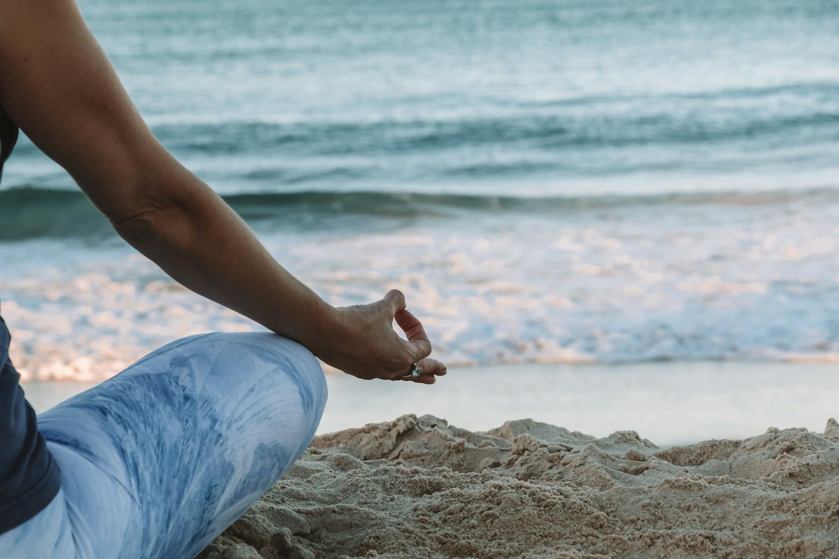 Mano en gesto de meditación sobre la arena